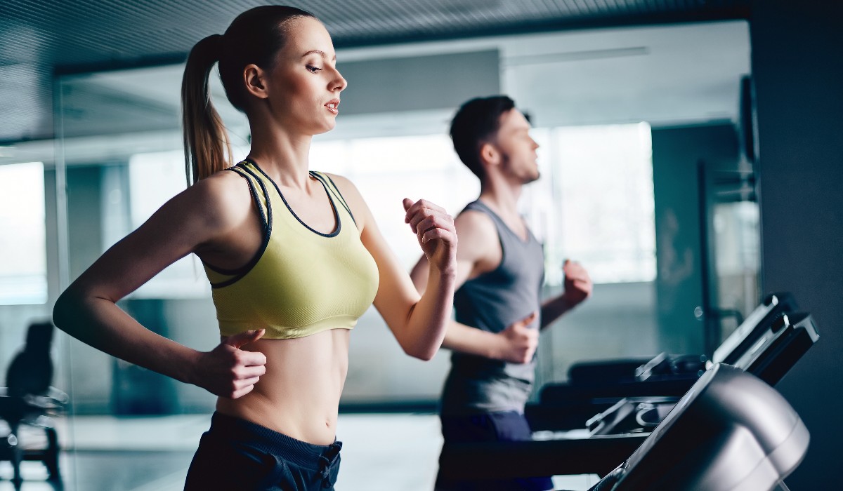 a woman and a man running next to each other on treadmills