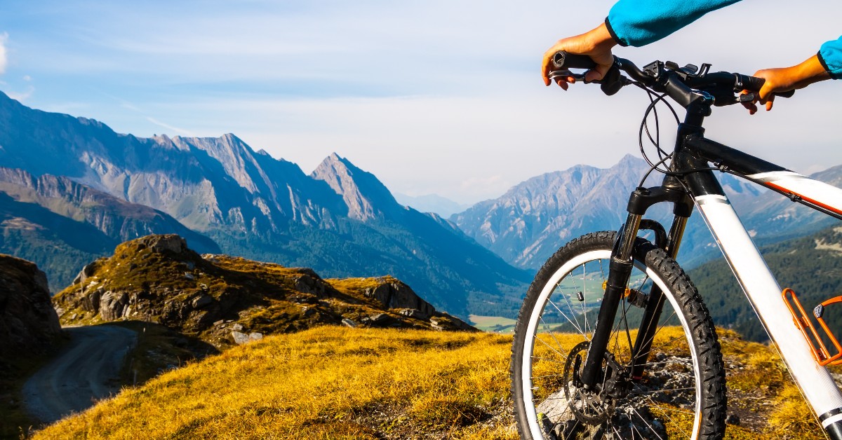 person with a bike on a mountain with a view of more mountains on the horizon