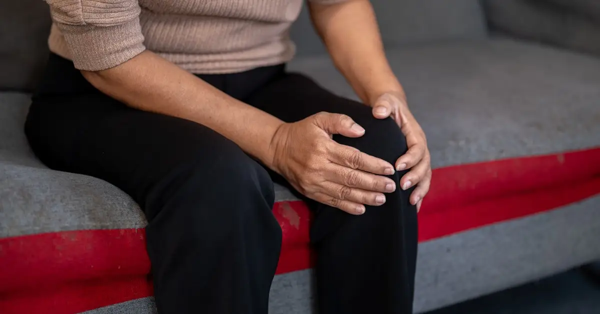woman holding her knee