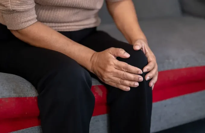 woman holding her knee